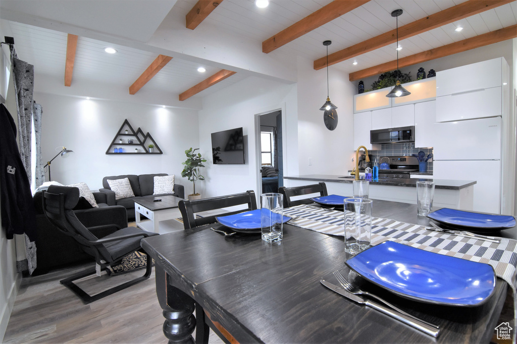 Dining room with recessed lighting, light wood-style floors, and beam ceiling