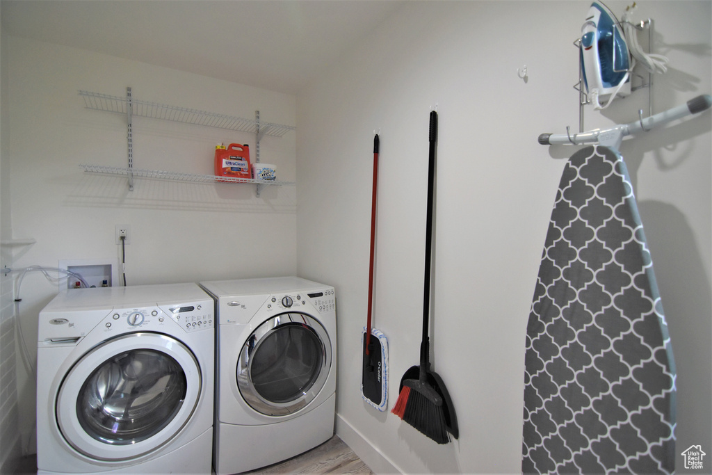 Washroom featuring light wood-style floors and washing machine and dryer