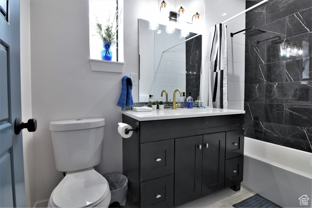 Full bathroom with vanity, toilet, and shower / bath combo with shower curtain