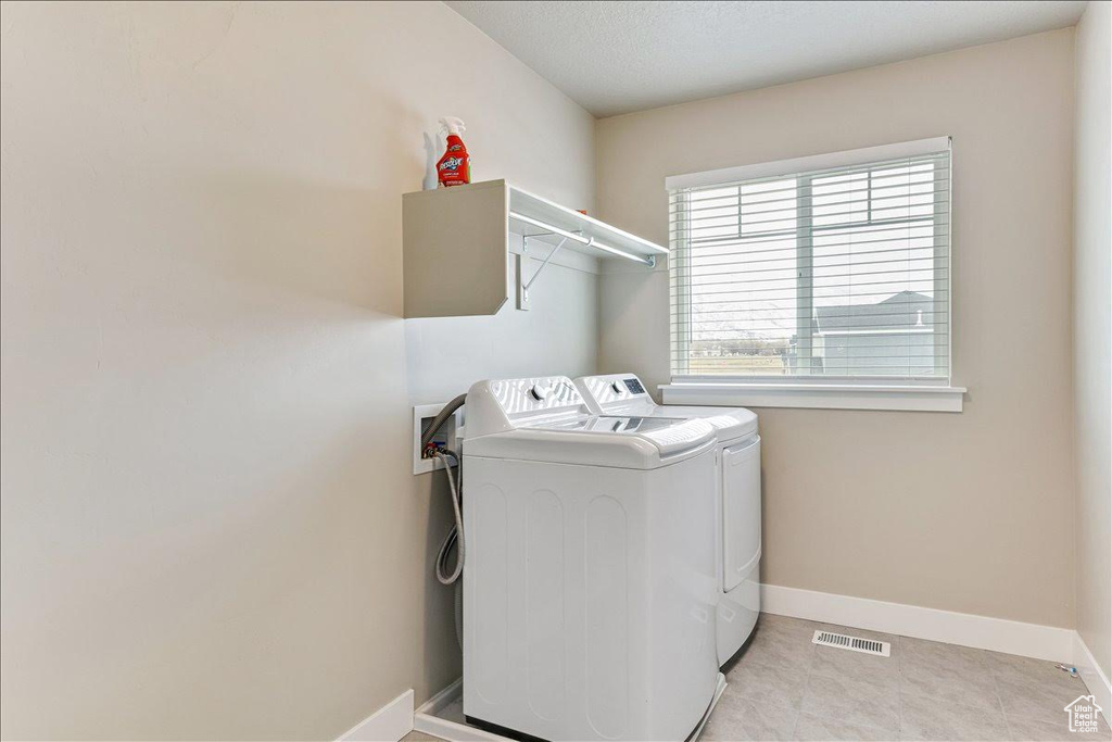 Laundry area with washing machine and clothes dryer and baseboards