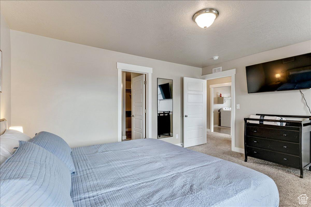 Carpeted bedroom featuring baseboards and a textured ceiling
