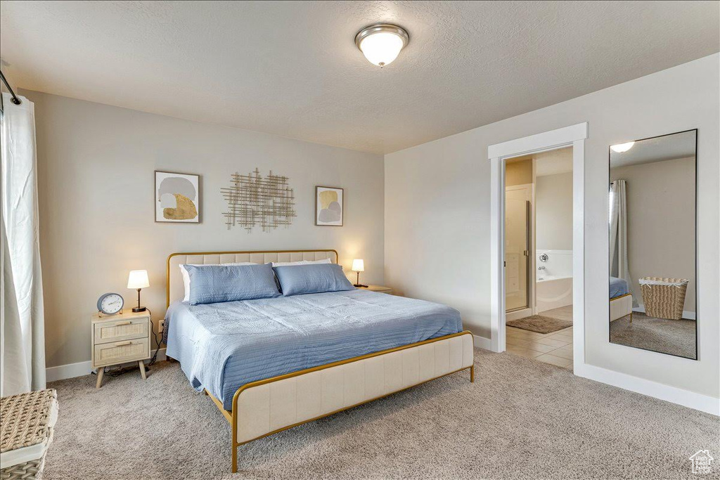 Bedroom featuring carpet, baseboards, and ensuite bath