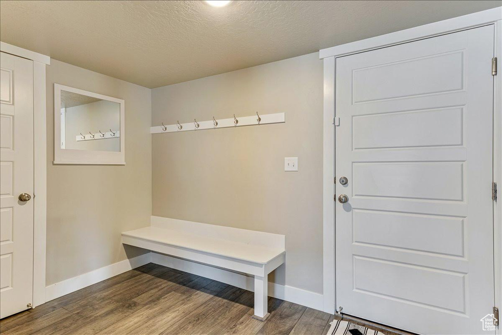 Mudroom with baseboards, wood finished floors, and a textured ceiling
