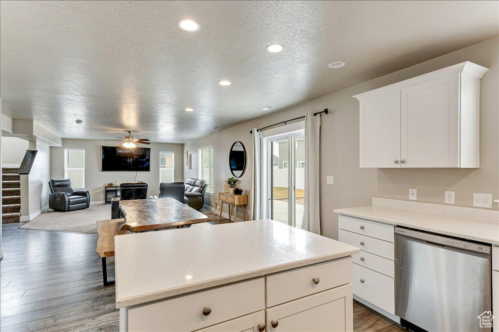 Kitchen with dishwasher, a textured ceiling, light wood finished floors, a center island, and healthy amount of natural light