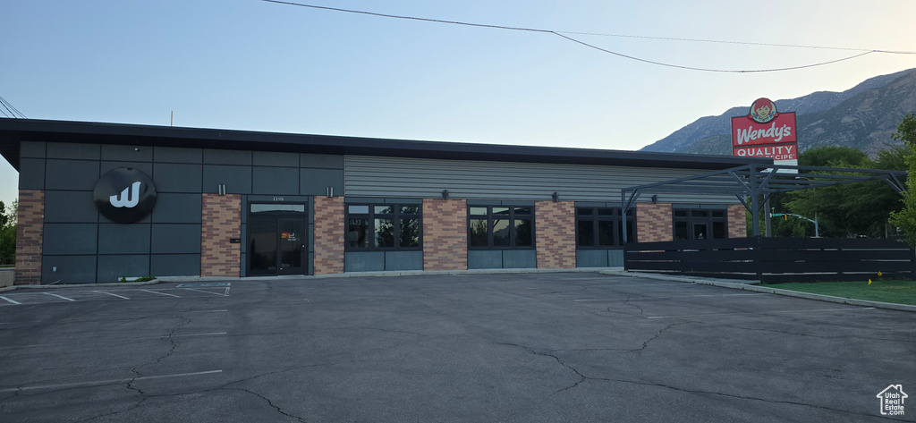 View of building exterior with uncovered parking and a mountain view