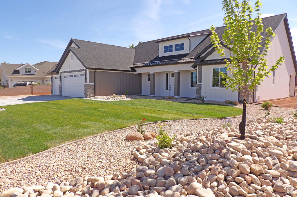 Craftsman-style home with a standing seam roof, metal roof, stone siding, a garage, and concrete driveway