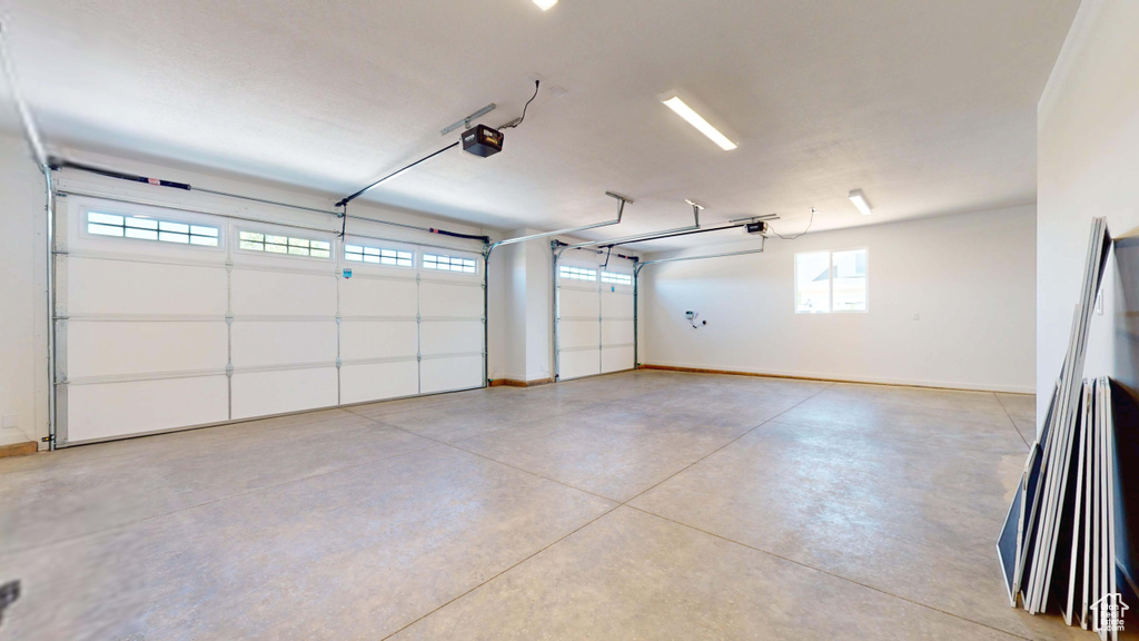 Garage featuring a garage door opener and baseboards
