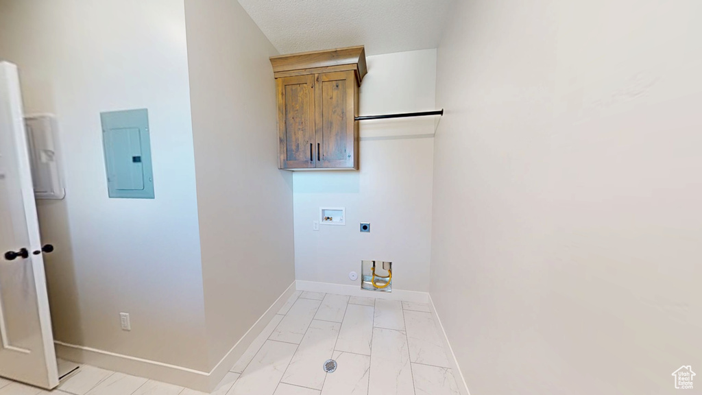 Laundry room with electric panel, hookup for an electric dryer, hookup for a washing machine, baseboards, and light marble finish floors