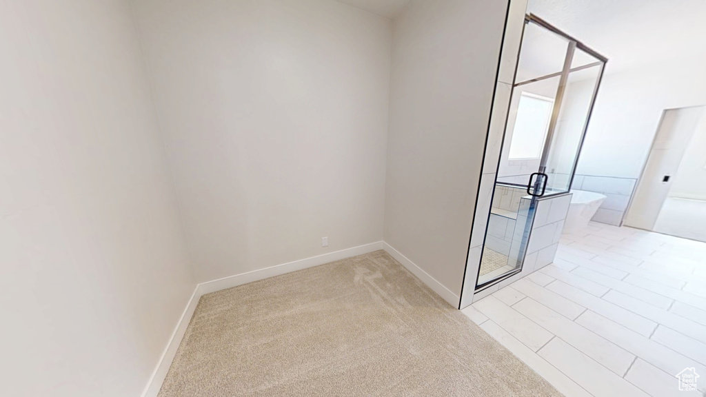 Empty room featuring light carpet and baseboards