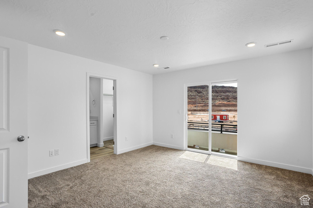 Carpeted spare room with baseboards and recessed lighting
