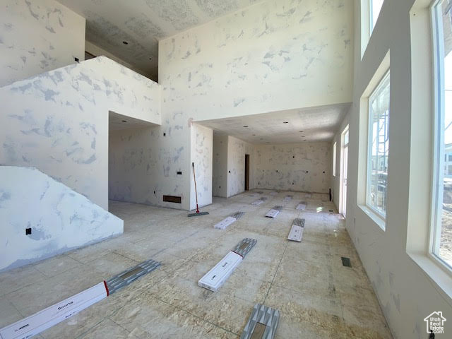 Unfurnished living room with a high ceiling