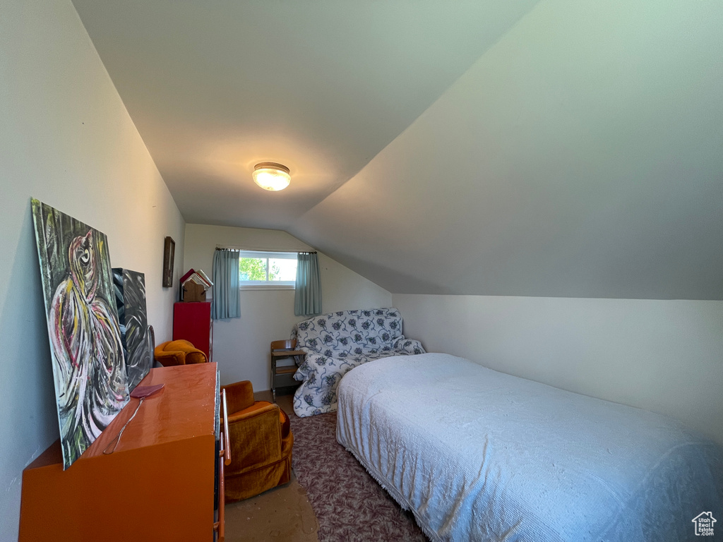 Carpeted bedroom featuring vaulted ceiling