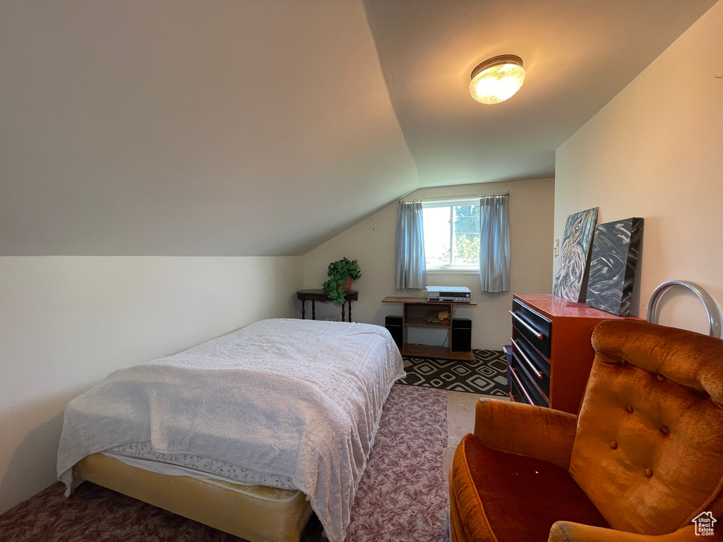 Bedroom featuring carpet floors and vaulted ceiling