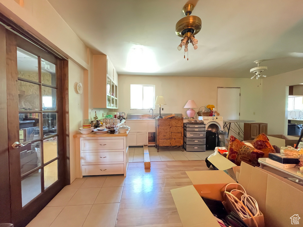 Kitchen with white cabinetry, open floor plan, light tile patterned floors, and a sink