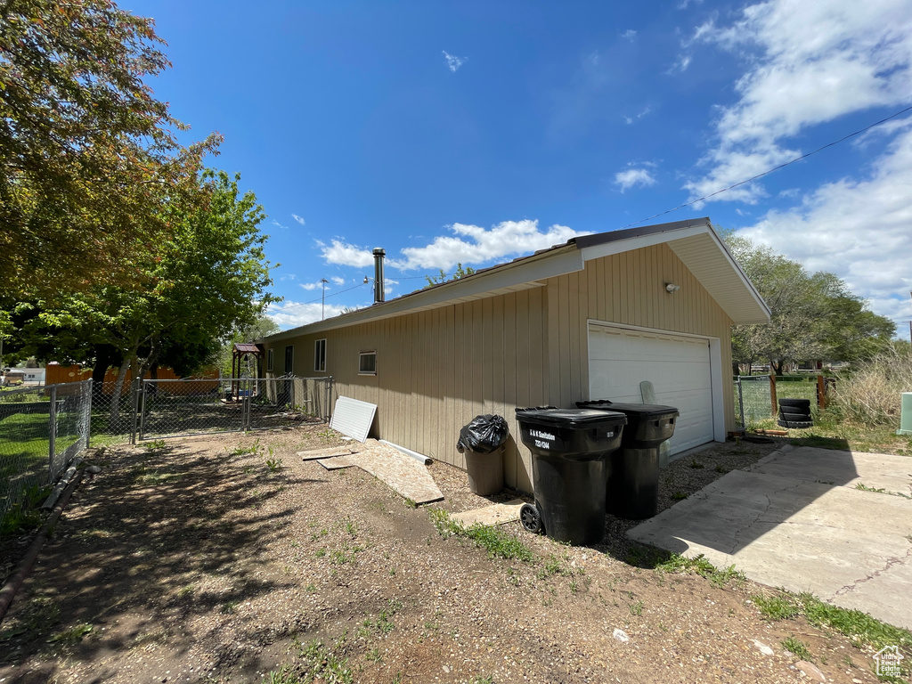 View of side of property with a garage and an outbuilding