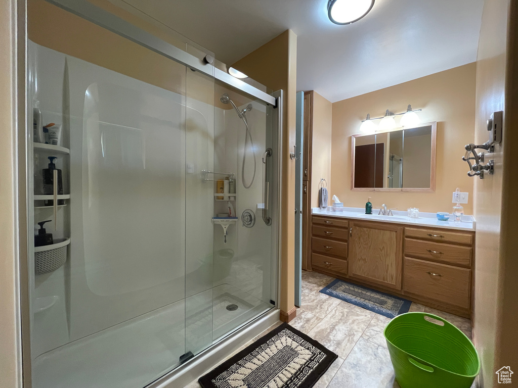 Full bath featuring a stall shower and vanity