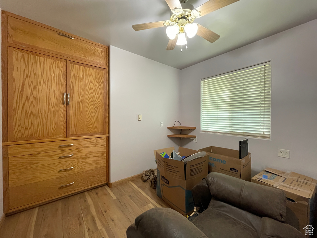 Sitting room with light wood finished floors, a ceiling fan, and baseboards