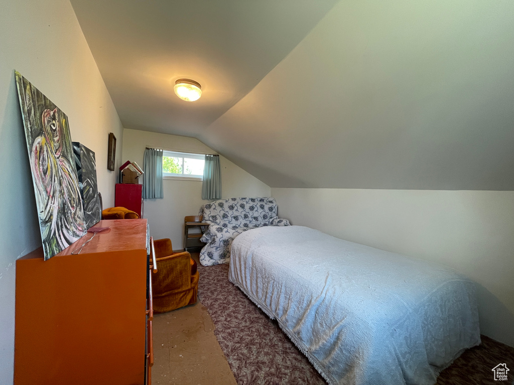 Bedroom with carpet flooring and lofted ceiling