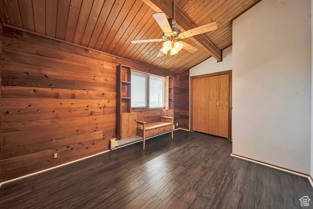 Unfurnished room featuring wood ceiling, ceiling fan, dark wood finished floors, and wood walls