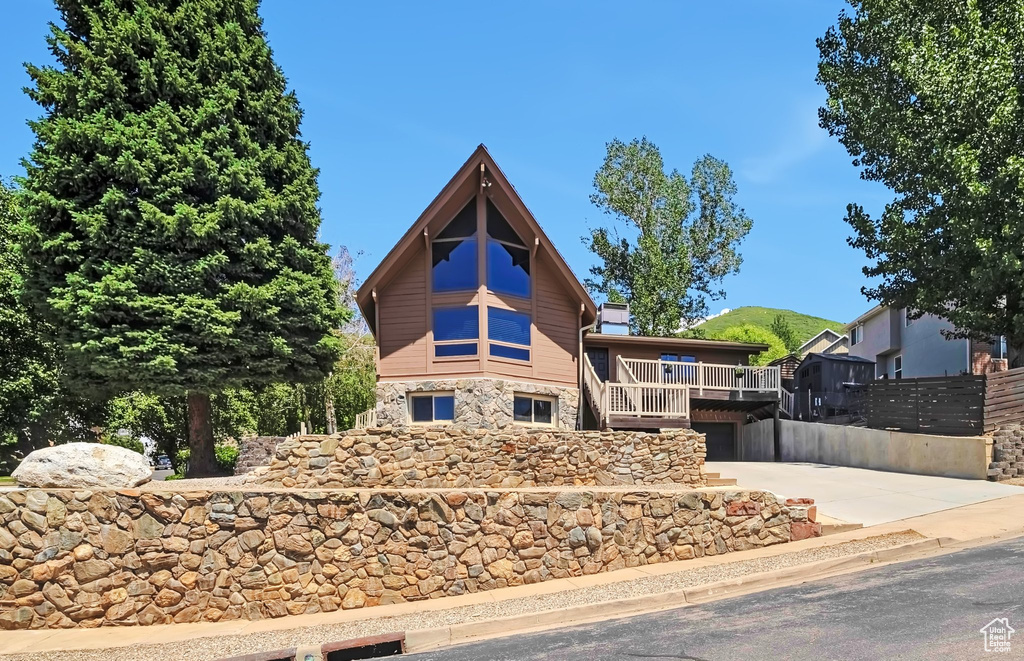 View of front facade with stone siding and concrete driveway