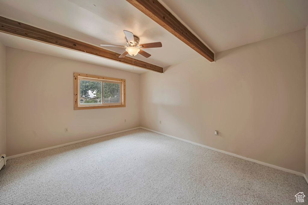 Unfurnished room featuring a ceiling fan, beam ceiling, carpet flooring, and baseboards