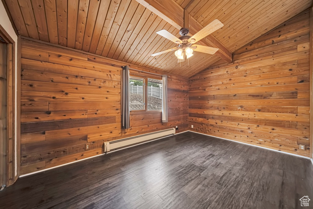 Spare room with baseboard heating, wood ceiling, dark wood-style floors, wooden walls, and ceiling fan