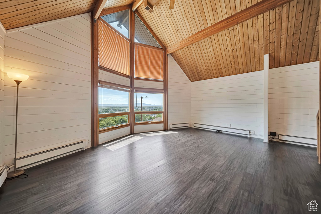 Unfurnished room featuring wooden walls, wood finished floors, a baseboard heating unit, wood ceiling with exposed beams, and high vaulted ceiling