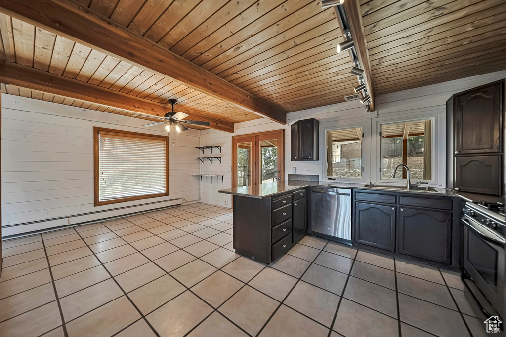 Kitchen featuring appliances with stainless steel finishes, a baseboard radiator, light tile patterned floors, a peninsula, and wooden ceiling with exposed beams