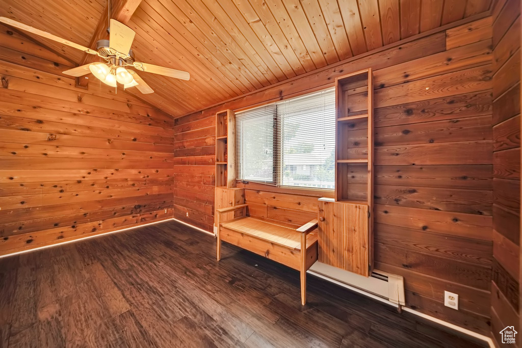 Spare room featuring wood ceiling, dark wood finished floors, vaulted ceiling, wood walls, and ceiling fan