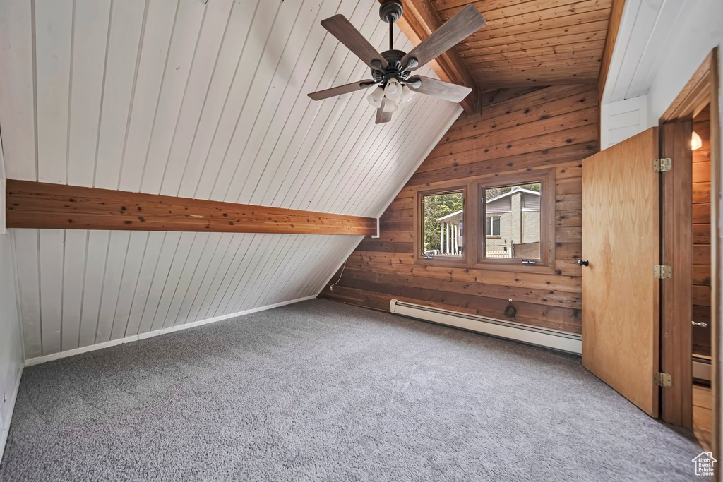 Bonus room featuring a baseboard radiator, wooden walls, carpet, ceiling fan, and wooden ceiling