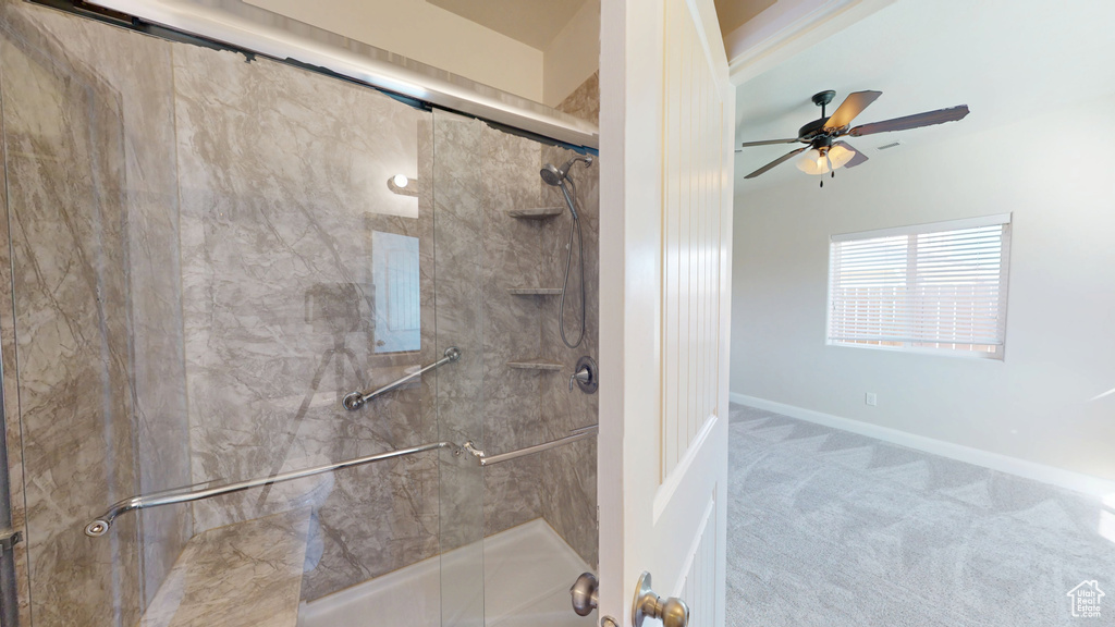 Bathroom featuring a shower stall, a ceiling fan, and baseboards