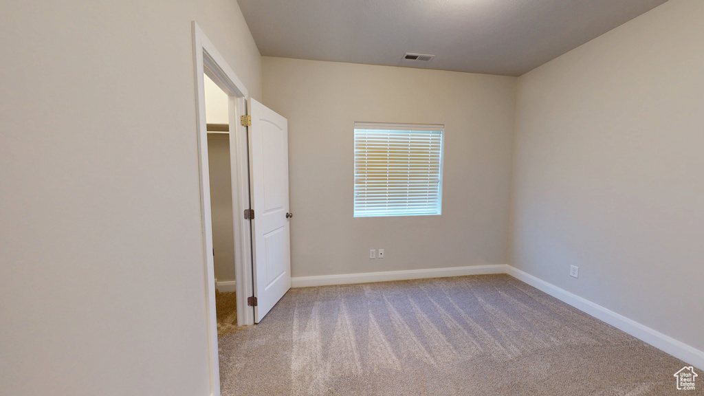 Unfurnished bedroom with carpet flooring and baseboards