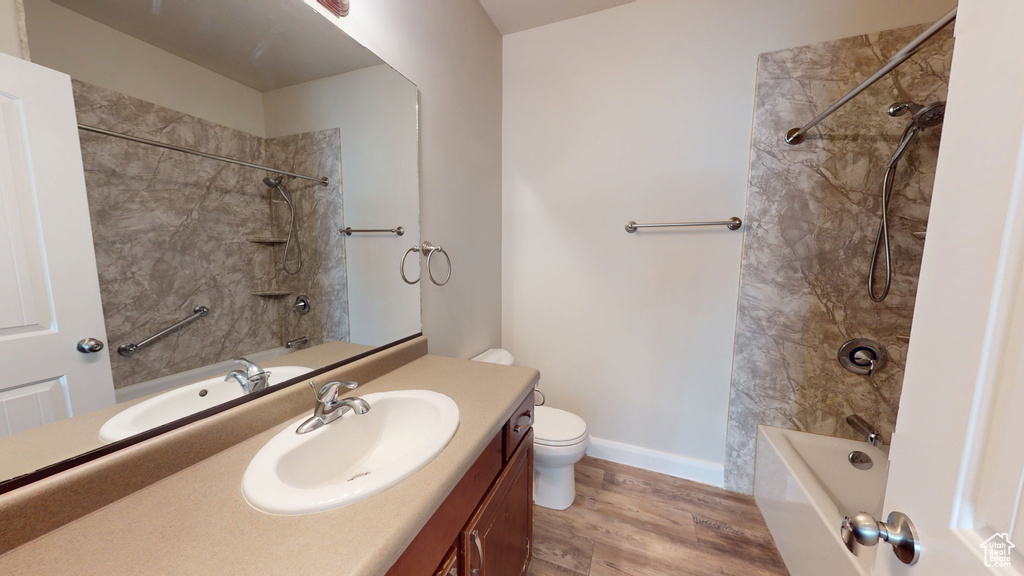 Bathroom with  shower combination, vanity, toilet, wood finished floors, and baseboards