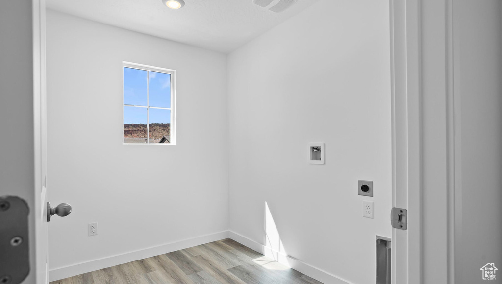 Laundry room featuring hookup for an electric dryer, light wood-type flooring, baseboards, and hookup for a washing machine