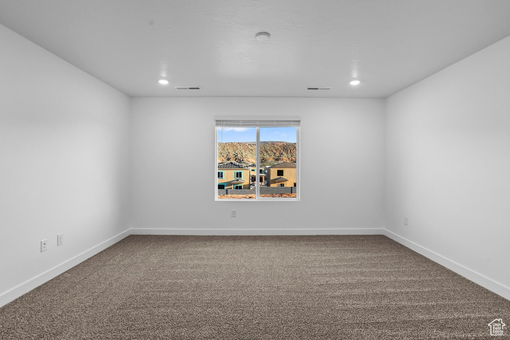 Unfurnished room featuring carpet flooring, baseboards, and recessed lighting