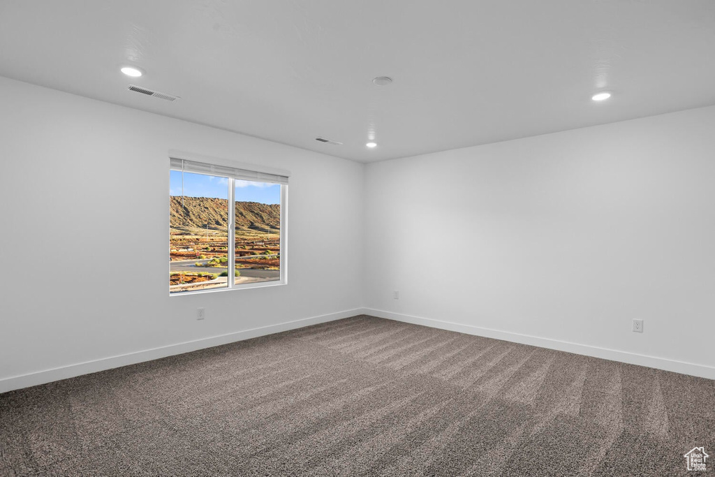 Carpeted empty room featuring recessed lighting and baseboards