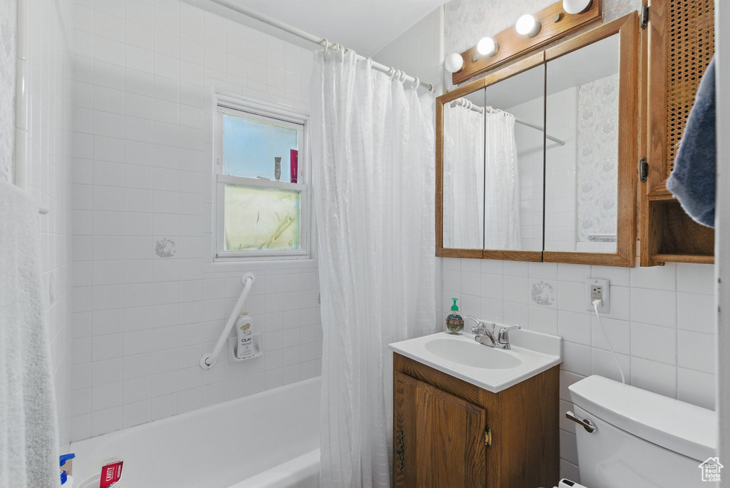 Full bath featuring vanity, toilet, and shower / bathtub combination with curtain