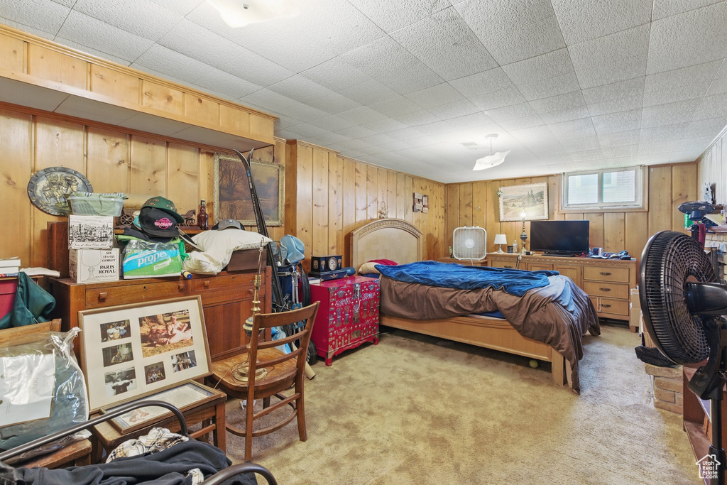 Bedroom with light carpet and wooden walls