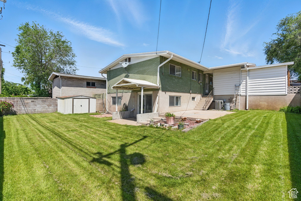 Back of property featuring a patio, central air condition unit, and a lawn