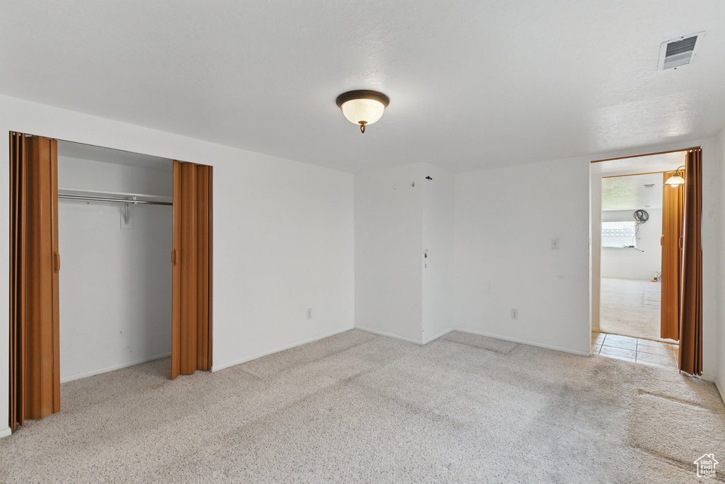 Unfurnished bedroom with carpet flooring, a closet, and baseboards