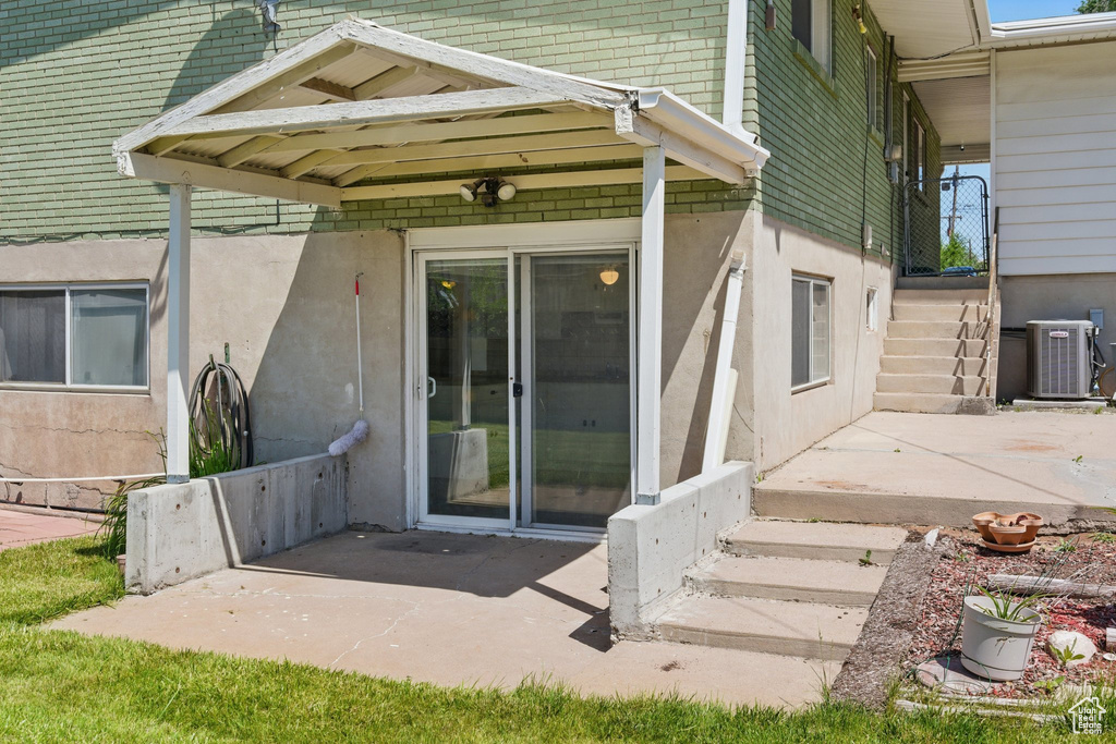 Entrance to property featuring central AC, a patio, and stucco siding