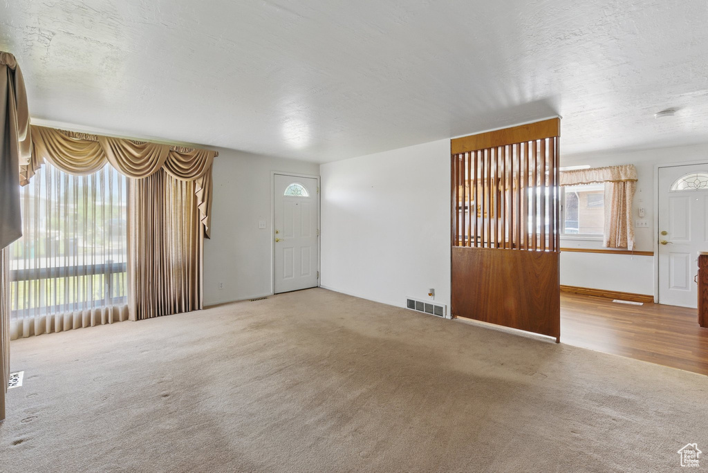 Unfurnished living room with plenty of natural light and carpet floors