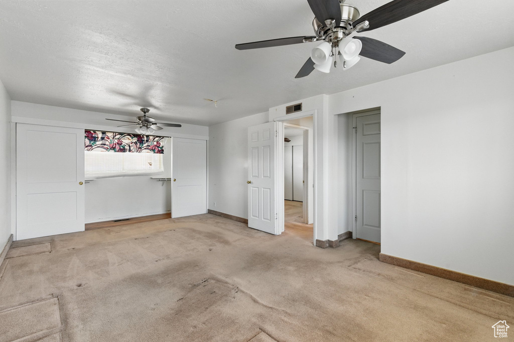 Unfurnished bedroom with baseboards, light carpet, and ceiling fan