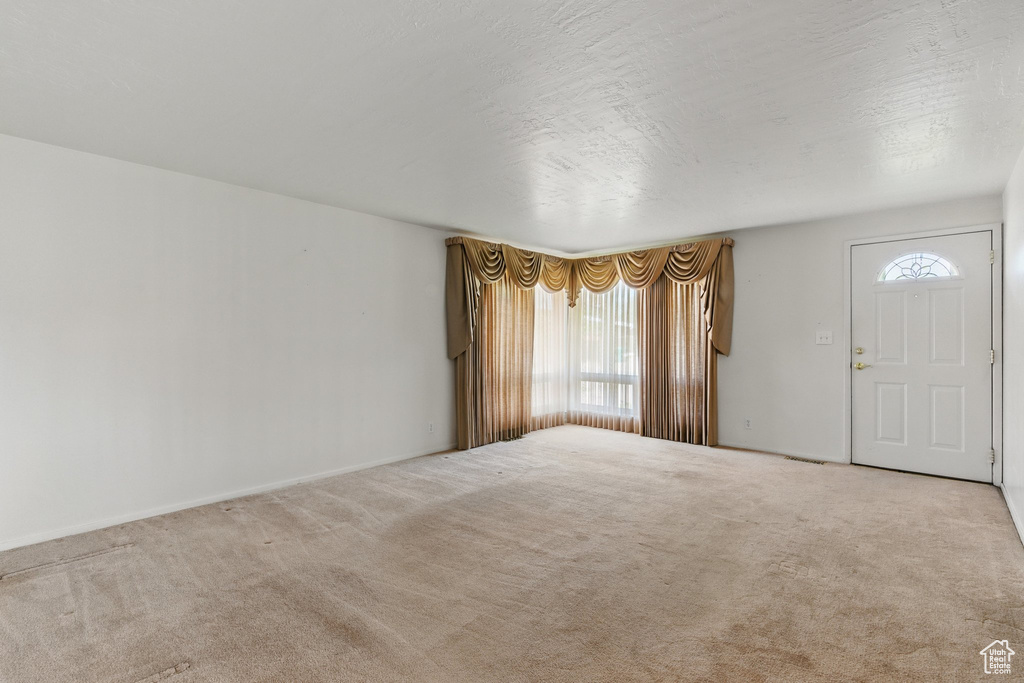 Entryway with carpet flooring and baseboards