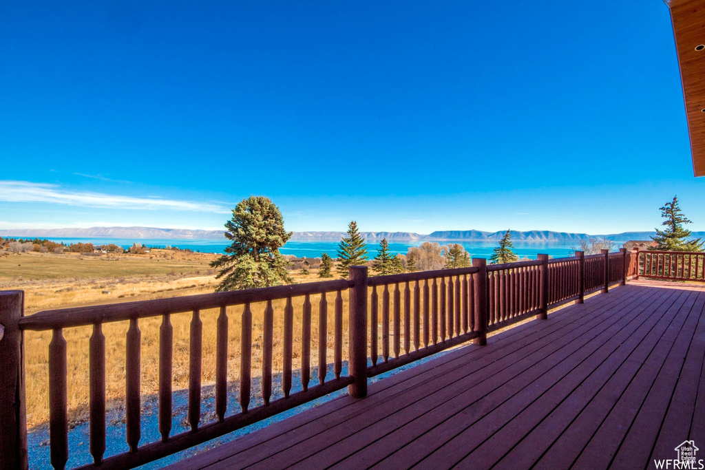 Wooden terrace featuring a water and mountain view
