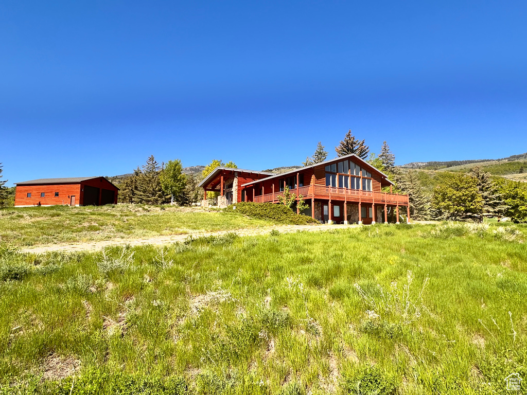 Rear view of house with a wooden deck and an outdoor structure