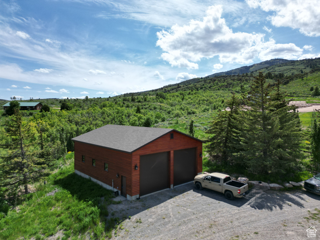Detached garage featuring a view of trees and a mountain view