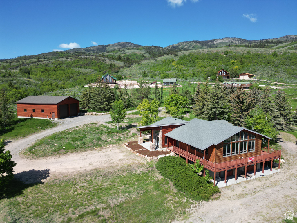 Aerial view of property and surrounding area with a forest and mountains