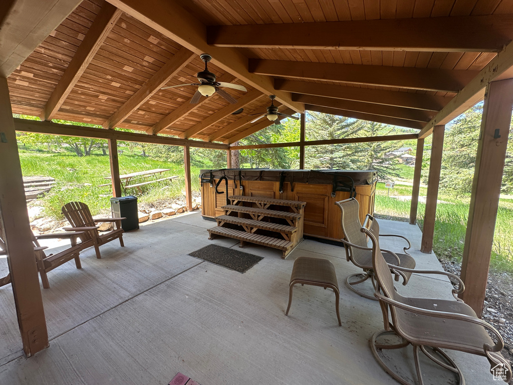 View of patio with a hot tub and a ceiling fan