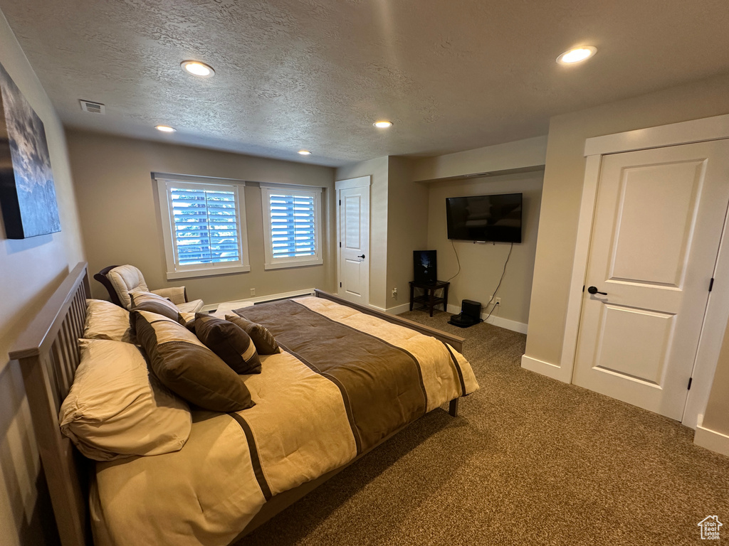 Carpeted bedroom featuring recessed lighting, a textured ceiling, and baseboards